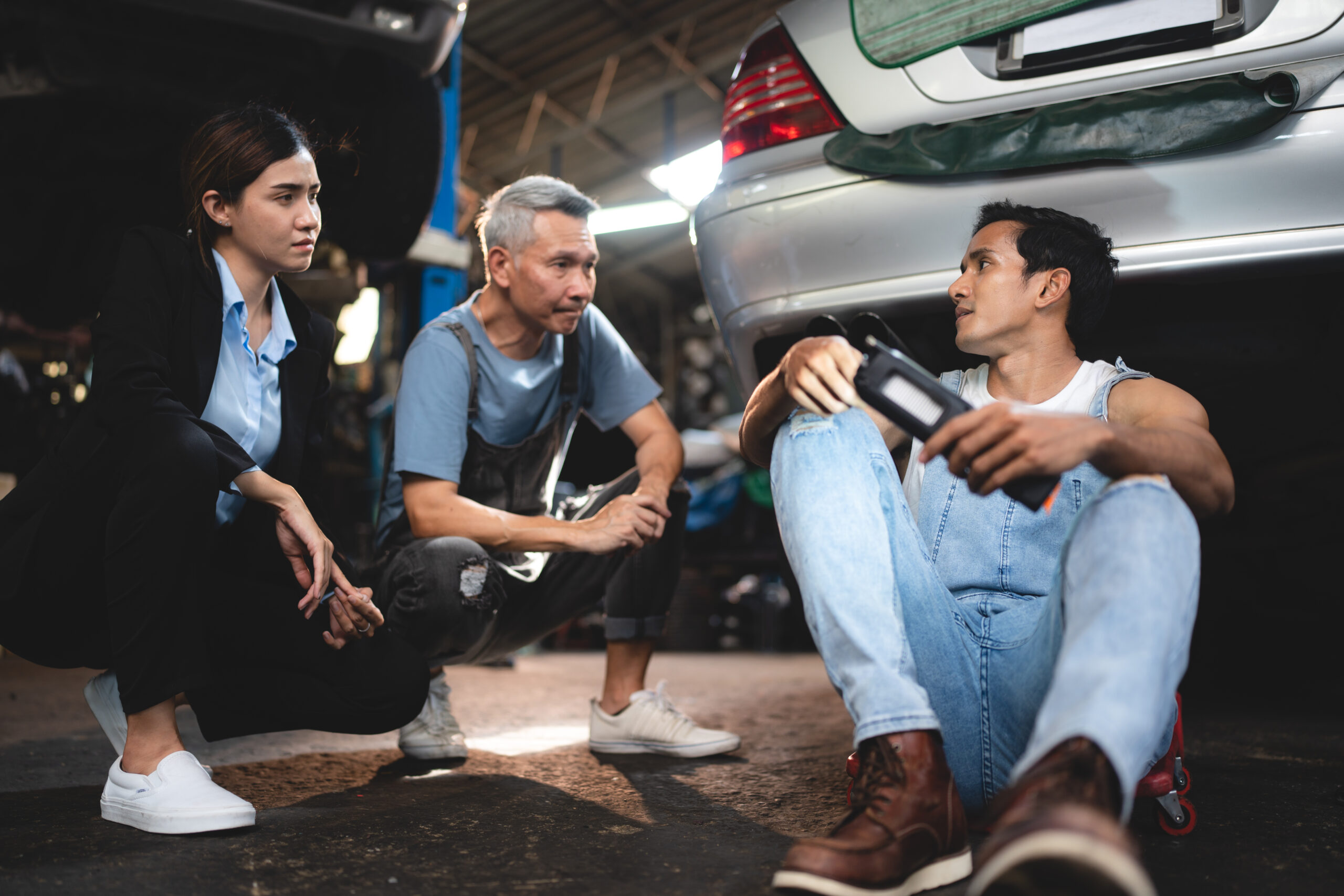 A well-equipped auto garage with a technician diligently working on a car, showcasing the expertise and professionalism of the service center.