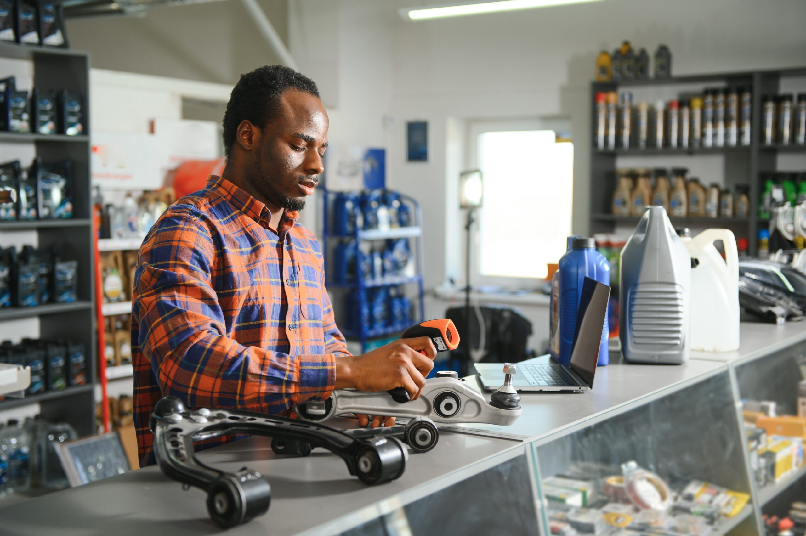 An auto parts store employee carefully inspects a newly received part, ensuring its quality and compatibility.