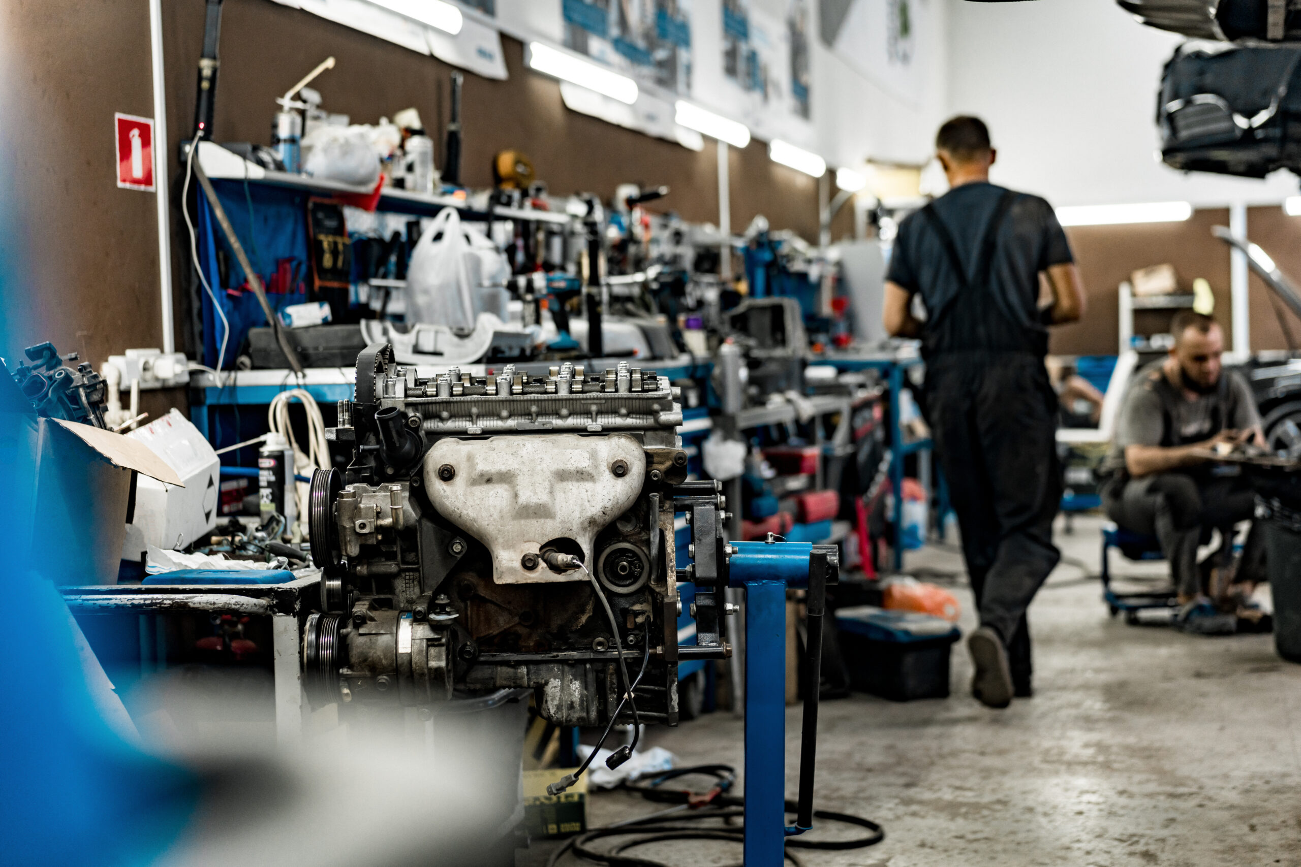 A well-lit car repair shop with tools and equipment neatly organized on the walls.