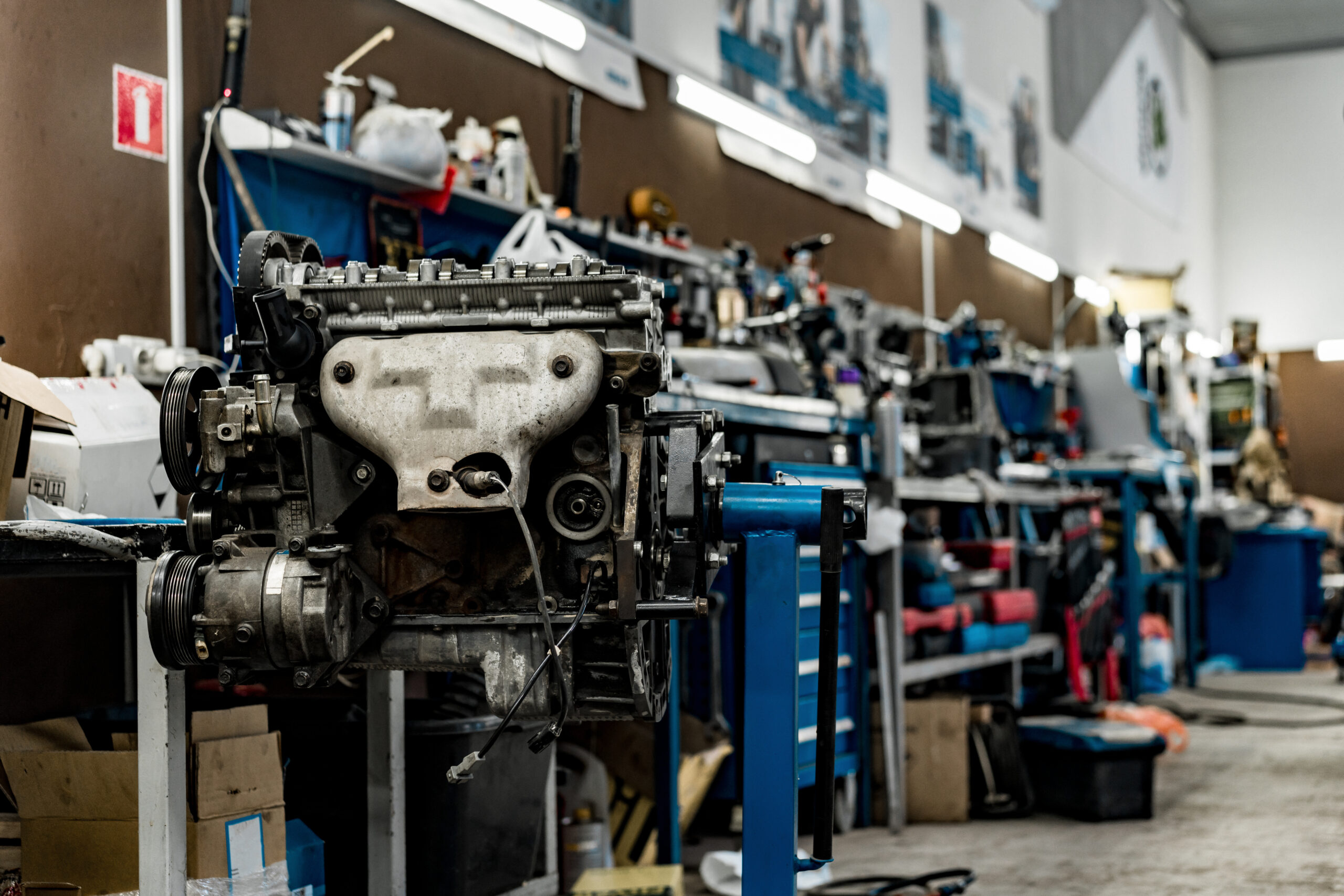 A well-lit car repair shop with tools and equipment neatly organized on the walls.