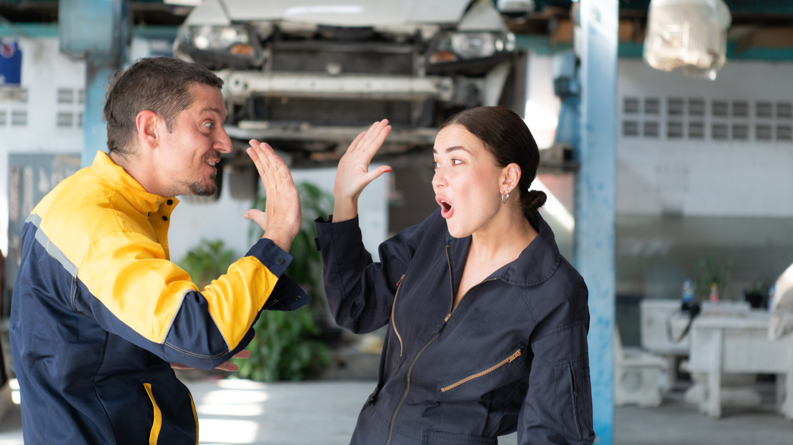 An engineer and a mechanic, side-by-side, discussing the inner workings of a vehicle's engine.