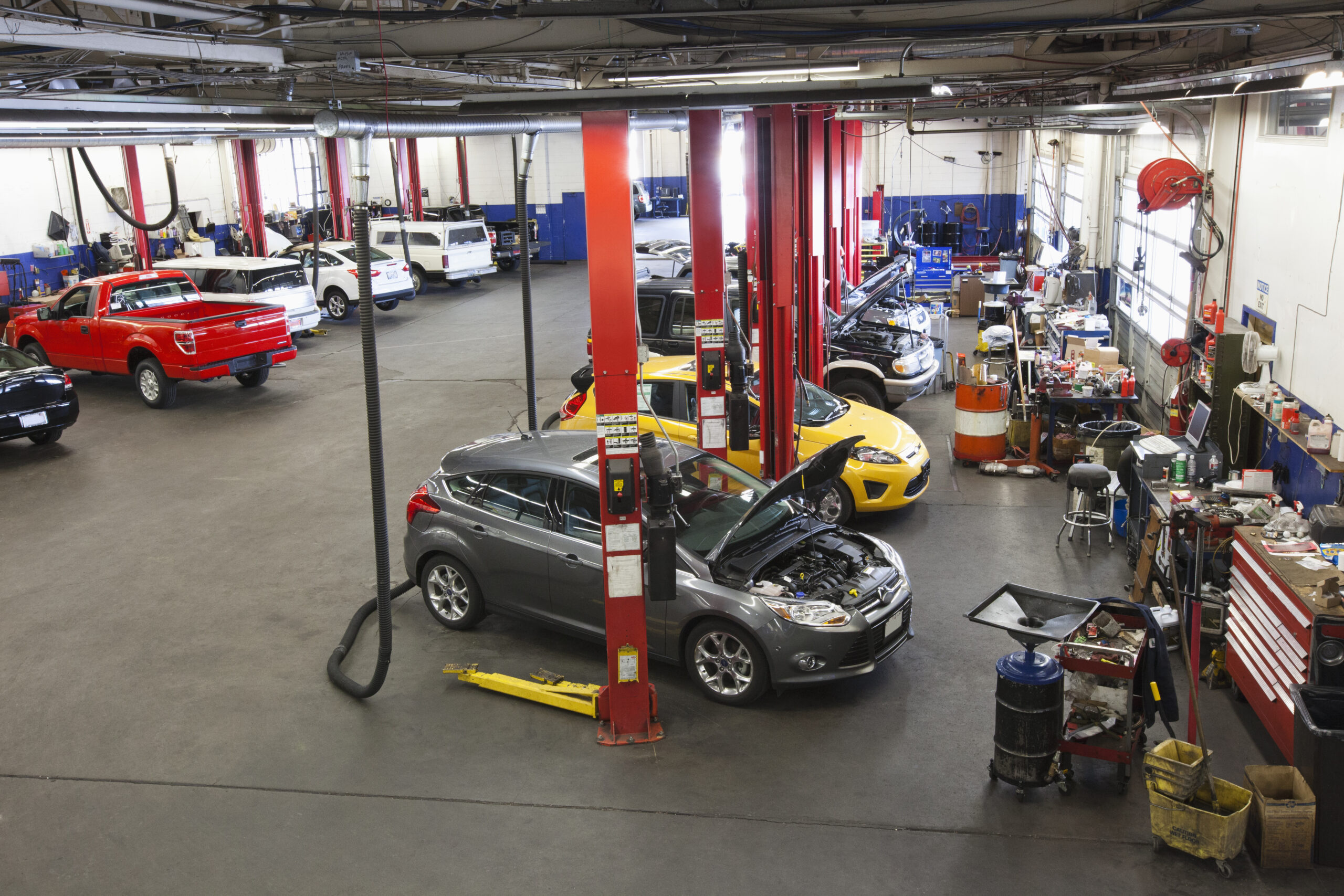 A bustling auto repair shop in Seattle filled with rows of cars and trucks awaiting service.